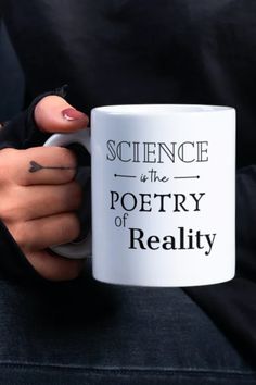 a woman holding a coffee mug with the words science is the poetry of reality