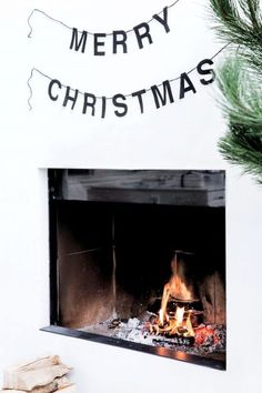 a fireplace with a merry christmas sign above it