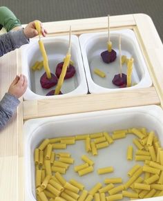 two children are playing with food made out of sticks and melted cheese in a bowl