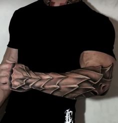 a man with a tattoo on his arm holding something in one hand and looking at the camera