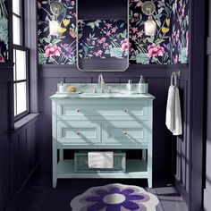 a bathroom with purple walls and floral wallpaper on the walls, along with a white rug