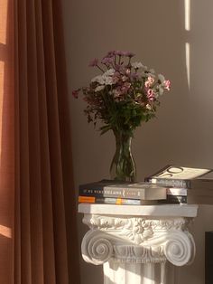 a vase filled with flowers sitting on top of a white table next to a window