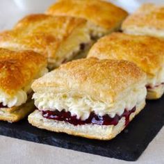 several biscuits and jelly sandwiches on a black plate