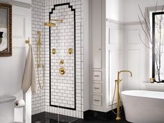 a white bathroom with black and gold accents