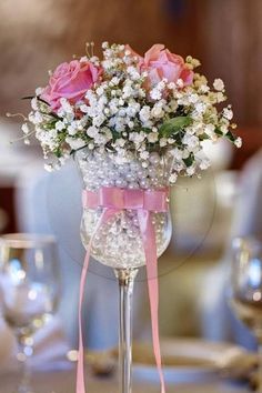 a vase filled with pink roses and baby's breath on top of a table