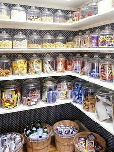 a pantry filled with lots of different types of food and snacks in glass containers on the shelves