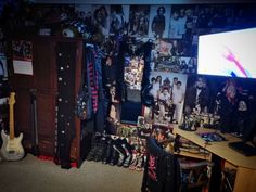 a room filled with lots of clothes and musical instruments on the wall next to a tv