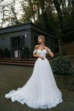 a woman in a white wedding dress posing for the camera