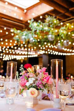 the table is set with candles, flowers and wine glasses for an elegant wedding reception