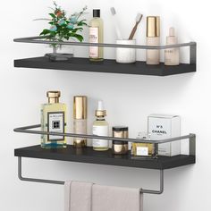 two black shelves with different types of cosmetics and personal care items on them, along with a white towel