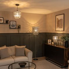 a living room with two couches, a table and pictures hanging on the wall