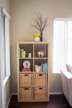 a living room with a book shelf and wicker baskets