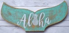 a wooden sign that says aloha with a pineapple painted on it's side