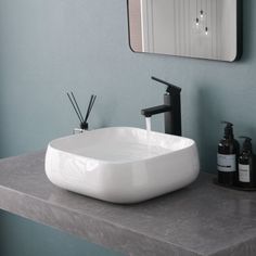 a bathroom sink sitting on top of a counter next to a soap dispenser