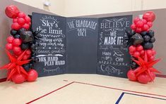 two red and black balloons in front of a chalkboard sign