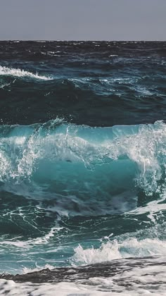 a person riding a surfboard on top of a wave in the ocean with blue water