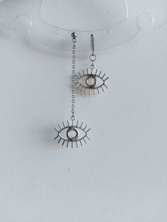 The earrings are decorated with silver pendants in the shape of brass eyes. The earrings are fastened with stainless steel hoops. Earring length - 7.0 cm (2.8 inches) Earrings are packed in a gift box Stainless steel silver chain with pendants in the shape of brass eyes. Chain length-  45.0 cm (18.0 inches) The necklace is packed in a gift box RECOMMENDATIONS FOR CARE: Do not wet, do not drop, and store in a dark box! - Remove jewelry before exercising, swimming, showering and sleeping. - Avoid Anime Earrings, Grunge Jewelry, Y2k Goth, Gothic Earrings, Eye Earrings, Goth Grunge, Silver Pendants, Earring Gifts, Evil Eye