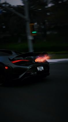 a black sports car driving down the street