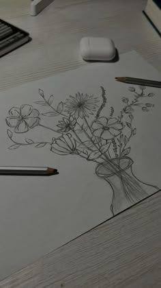 a pencil drawing flowers in a vase on top of a table next to a computer mouse