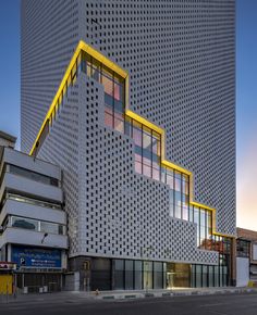 the building is made up of many different types of windows and has yellow trim on it