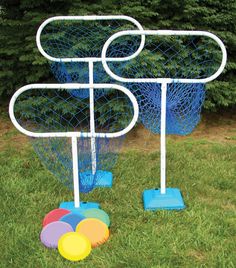 an outdoor game set in the grass with plastic balls on it and two blue buckets behind it