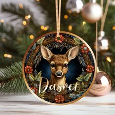 a christmas ornament with a deer on it and the words dashet in front of a christmas tree