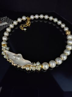 Beautiful choker necklace with white Majorca pearls. The necklace is in the classic 50s style and gives a touch of refined elegance to your look. The necklace is made with rough Majorca pearls, they are pearls with a glass heart and covered with shell substance, they have a perfect round shape and are very bright. The necklace has an adjustable lobster clasp with a 6cm extension. The necklace is asymmetrical thanks to the enamelled leaf component which gives a romantic and refined touch. The necklace is twisted, holds its shape perfectly but at the same time sits perfectly on the neck. This type of necklace is very versatile, suitable for every day but at the same time it is perfect for an evening dress for a special occasion. This pearl necklace cannot be missing from your jewelry collect Classic Pearl Pendant Necklace For Party, Classic Pearl Necklace With Pendant For Party, Formal Pearl White Beaded Necklace With Pearl Drop, Elegant Single Strand White Choker, Elegant White Beaded Choker Necklace, Elegant White Single Strand Choker, Party Pearl Necklace With Pearl Pendant, Formal Pearl Beaded Necklaces With Pearl Drop, Classic Pearl Embellished Necklaces For Party