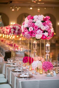 the tables are decorated with pink and white floral centerpieces, candles and wine glasses