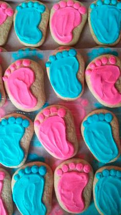 decorated cookies with pink and blue icing in the shape of footprints on top of each cookie