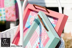 two colorful frames sitting next to each other in front of a white basket with handles