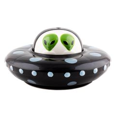 a black and white object with two green alien heads