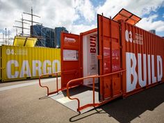 an orange cargo container sitting on top of a parking lot next to other shipping containers