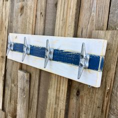 a blue and white coat rack on a wooden fence