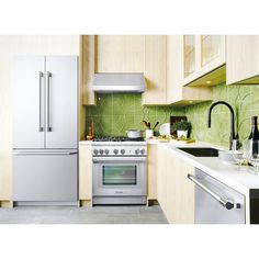 a modern kitchen with green tile backsplash and stainless steel appliances, including an oven