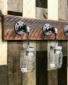 mason jars are hung on the wall with hooks