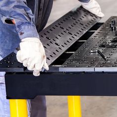 two men are working on a metal table that is being worked on by the same person