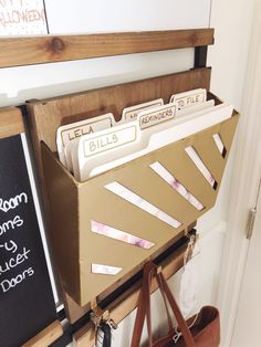 a brown bag hanging from a wall next to a wooden shelf with files in it