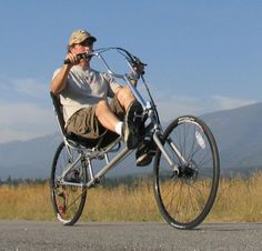 a man sitting in a chair on top of a bike while talking on a cell phone