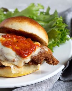 a chicken parmesan sandwich on a plate with lettuce