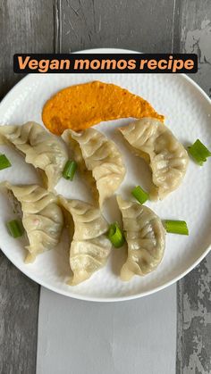 a white plate topped with dumplings and sauce