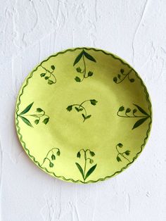 a green plate sitting on top of a white wall