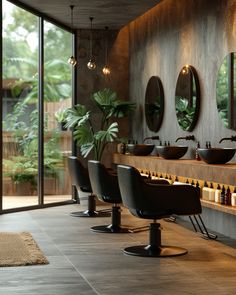 a bathroom with two sinks and mirrors on the wall, along with chairs in front of them