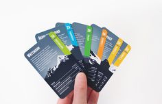 four business cards held in the palm of a person's hand on a white background