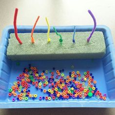 a blue tray filled with lots of different colored beads and some writing on top of it