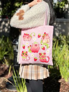 Overview: Cotton Tote Bag: -34 x 38 cm(B x H). -13.4 x 15 in(B x H). -Inner Pocket. -Zipper at the mouth of the bag. -Single-sided heat press print. -Rare pink color. This beautiful handmade tote bag is made of premium quality, pink cotton, and features a full of cute strawberry cat print. The bag is designed with functionality in mind, featuring a secure zipper closure and a small inner pocket, perfect for keeping your essentials organized. The bag is also made with heat transfer technology, en Kawaii Cat Design Shoulder Bag For Daily Use, Kawaii Shoulder Bag With Cat Design For Daily Use, Casual Pink Bag With Animal Design, Cute Cat Design Shoulder Bag For Daily Use, Pink Cat Design Shoulder Bag Gift, Pink Rectangular Bag With Cat Design, Kawaii Cat Design Tote Bag, Kawaii Tote Bag With Cat Design, Cute Pink Cat Design Bag