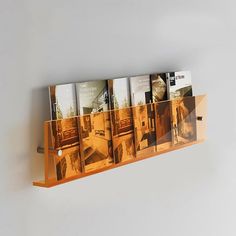 a wooden shelf holding several magazines on it's sides and hanging from the wall