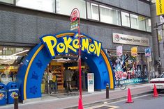 an entrance to a pokemon store on a city street