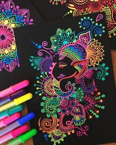 two coloring books with markers and pens on the table next to them are colorfully decorated