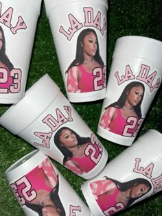 six plastic cups with images of the same woman on them, all in pink and white