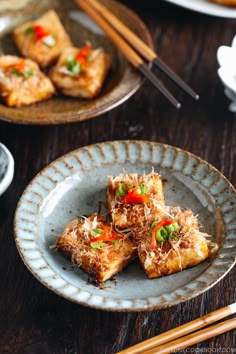 some food is on a blue plate and chopsticks are in the bowl next to it